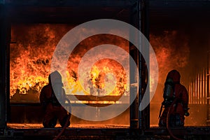 Firefighter Concept. Fireman using water and extinguisher to fighting with fire flame. firefighters fighting a fire with a hose an