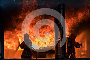 Firefighter Concept. Fireman using water and extinguisher to fighting with fire flame. firefighters fighting a fire with a hose an