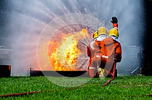 Firefighter Concept. Fireman using water and extinguisher to fighting with fire flame. firefighters fighting a fire with a hose an