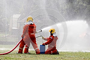 Firefighter Concept. Fireman using water and extinguisher to fighting with fire flame. firefighters fighting a fire with a hose an