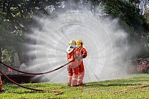 Firefighter Concept. Fireman using water and extinguisher to fighting with fire flame. firefighters fighting a fire with a hose an