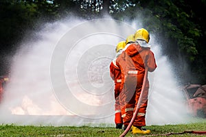 Firefighter Concept. Fireman using water and extinguisher to fighting with fire flame. firefighters fighting a fire with a hose an