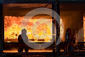 Firefighter Concept. Fireman using water and extinguisher to fighting with fire flame. firefighters fighting a fire with a hose an