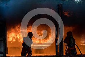 Firefighter Concept. Fireman using water and extinguisher to fighting with fire flame. firefighters fighting a fire with a hose an