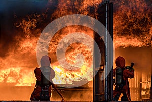 Firefighter Concept. Fireman using water and extinguisher to fighting with fire flame. firefighters fighting a fire with a hose an