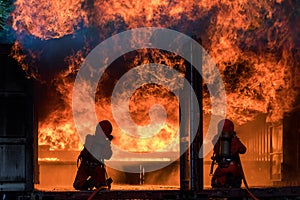 Firefighter Concept. Fireman using water and extinguisher to fighting with fire flame. firefighters fighting a fire with a hose an