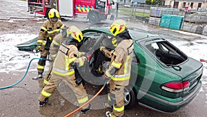 Firefighter cutting car doors with hydraulic cutter. Car accident