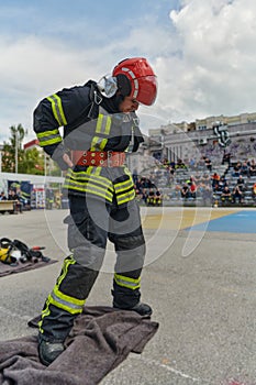 A firefighter dons the essential components of their professional gear, embodying resilience, commitment, and readiness