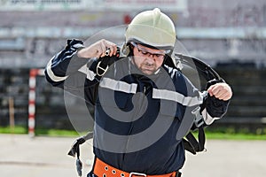 A firefighter dons the essential components of their professional gear, embodying resilience, commitment, and readiness