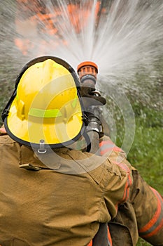 Firefighter dousing house fire