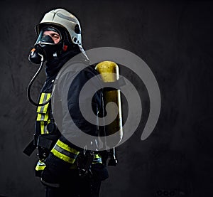 Firefighter dressed in uniform and an oxygen mask.