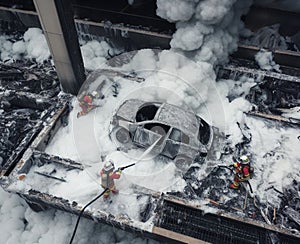 Firefighter Extinguish Burning melting ev electric Car with chemical foam, on a parking lot daytime