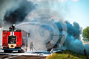 firefighter extinguishes a burning car after an accident