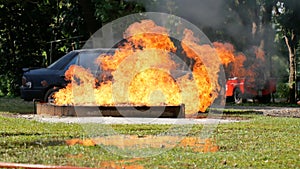 Firefighter fighting with flame using fire hose chemical water foam spray engine. Fireman wear hard hat, body safe suit uniform