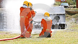 Firefighter fighting with flame using fire hose chemical water foam spray engine. Fireman wear hard hat, body safe suit uniform