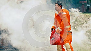 Firefighter fighting with flame using fire hose chemical water foam spray engine. Fireman wear hard hat, body safe suit uniform