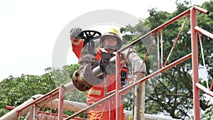 Firefighter fighting with flame using fire hose chemical water foam spray engine. Fireman wear hard hat, body safe suit uniform fo
