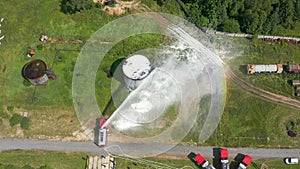 Firefighter or fireman on fire truck practicing at the training ground or range with fire extinguishing foam. Fire