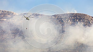 A firefighter helicopter rushes to help put out a wildfire