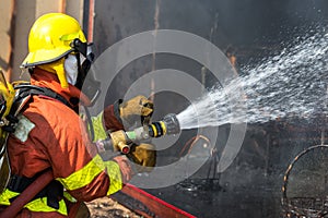 Firefighter hold and adjust nozzle and fire hose spraying water