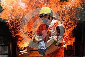 Firefighter holding child boy to save him  fire and smoke,Firemen rescue the boys from fire