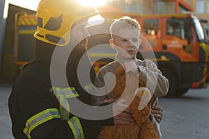 Firefighter holding child boy to save him in fire and smoke,Firemen rescue the boys from fire