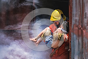 Firefighter holding child boy to save him in fire and smoke Firemen rescue the boys