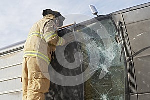 Firefighter Inspecting A Crashed Car