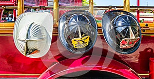 Firefighter lieutenant and captain helmets hanging on a fire truck