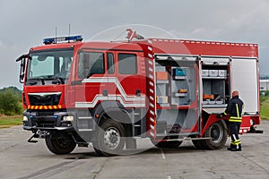 A firefighter meticulously prepares a modern firetruck for a mission to evacuate and respond to dangerous situations