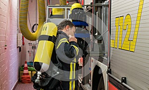 Firefighter with oxygen cylinder on the fire truck