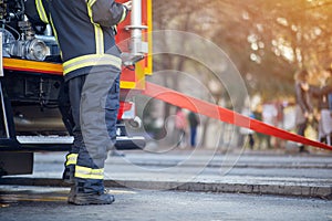 Firefighter in protective uniform. Fireman standing near a fire truck. Fire truck with equipment