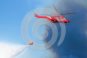 Firefighter rescue helicopter with helitanker droping water photo