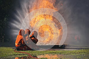 Firefighter Rescue team training in fire fighting extinguisher. Firefighter teamwork fighting with flame using fire hose chemical