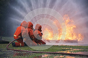 Firefighter Rescue team training in fire fighting extinguisher. Firefighter teamwork fighting with flame using fire hose chemical