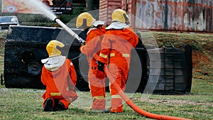 Firefighter Rescue team training in fire fighting extinguisher. Firefighter teamwork fighting with flame using fire hose chemical