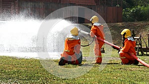 Firefighter Rescue team training in fire fighting extinguisher. Firefighter teamwork fighting with flame using fire hose chemical