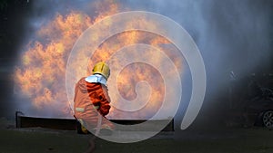 Firefighter Rescue training in fire fighting extinguisher. Firefighter fighting with flame using fire hose chemical water foam