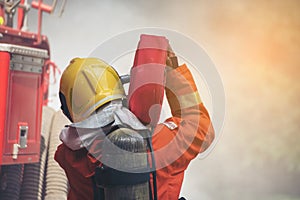 Firefighter Rescue training in fire fighting extinguisher. Firefighter fighting with flame using fire hose chemical water foam