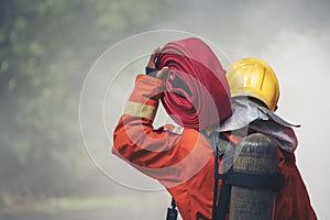 Firefighter Rescue training in fire fighting extinguisher. Firefighter fighting with flame using fire hose chemical water foam