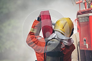 Firefighter Rescue training in fire fighting extinguisher. Firefighter fighting with flame using fire hose chemical water foam