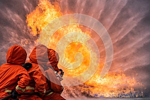 Firefighter Rescue training to stop buning flame, Fireman wear hard hat and safety uniform suit for protection burn photo