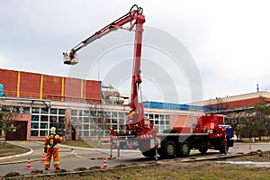 Firefighter rescuers at work in fireproof suits came to extinguish a fire in a fire truck and pull out a ladder cradle lift at a