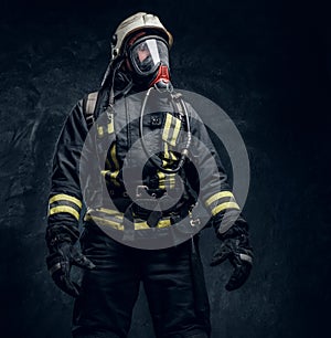 Firefighter in safety helmet and oxygen mask wearing protective clothes.