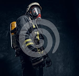 Firefighter in safety helmet and oxygen mask wearing protective clothes.