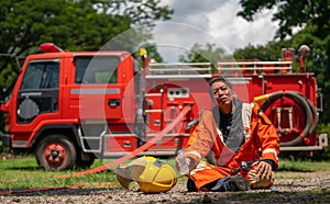 Firefighter sit in front of fire truck or fire engine and look at camera that look like he finish and succes to distinguish fire
