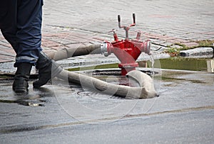 Firefighter stands near a hose connected to a hydrant