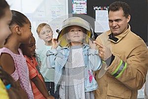 Firefighter teaching  fire safety to school kids at school