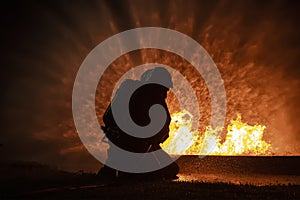 Firefighter training, fireman using water and extinguisher to fighting with fire flame in an emergency situation., under danger