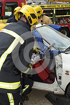 Firefighter using jaws of life at a car crash